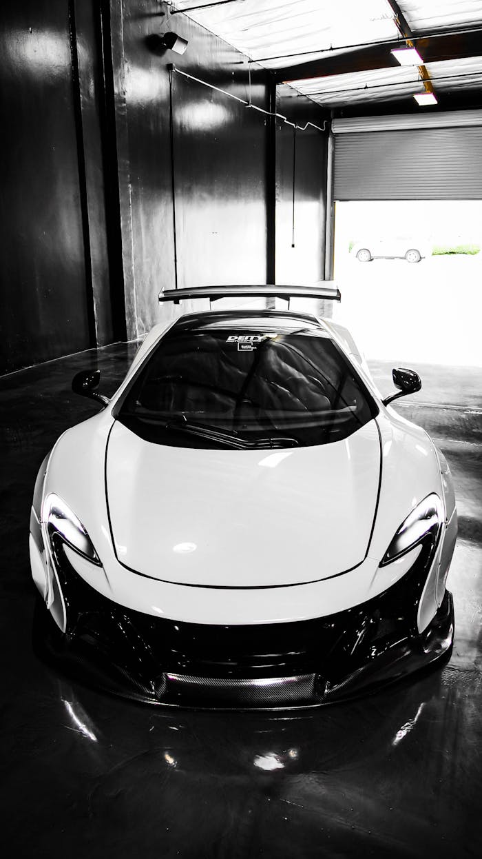 gallery-06 White sports car in a modern industrial garage, perfect for luxury automotive enthusiasts.